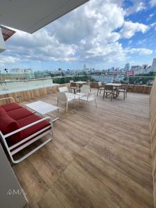 a large deck with chairs and tables on a roof at Acogedor Apartamento Céntrico in Santo Domingo