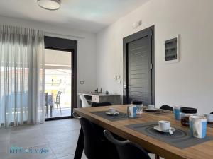 uma sala de jantar com uma mesa de madeira e um quarto com uma varanda em Magic Kefalonia Villa em Spartia
