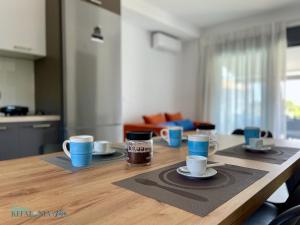 a wooden table with cups and saucers on it at Magic Kefalonia Villa in Spartia