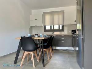 uma cozinha com uma mesa e cadeiras e um frigorífico em Magic Kefalonia Villa em Spartià