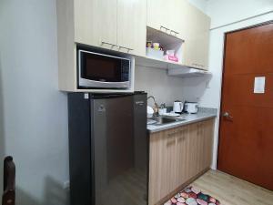 een keuken met een magnetron en een koelkast bij Bacolod Mesavirre Condominium in Bacolod