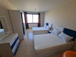 ein kleines Zimmer mit 2 Betten und einem Fenster in der Unterkunft Azha ain sokhna luxury chalet - families only - 155sqm special weekly monthly rates in Ain Suchna