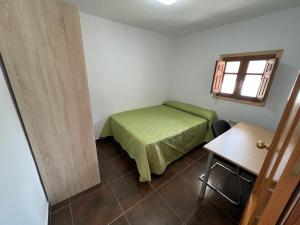 een slaapkamer met een bed, een tafel en een raam bij Casa Elsa Ceuta in Ceuta