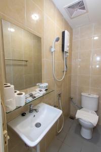 a bathroom with a toilet and a sink and a shower at Southern Tip Hotel in Pontian Kecil