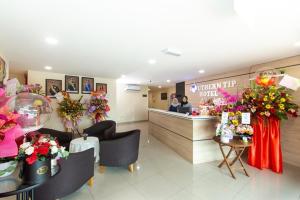 a lobby of a flower shop with two people at the counter at Southern Tip Hotel in Pontian Kecil