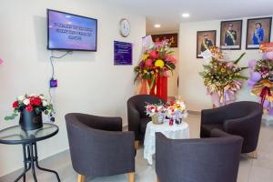 a waiting room with chairs and a table with flowers at Southern Tip Hotel in Pontian Kecil