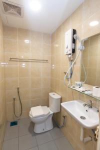 a bathroom with a toilet and a sink at Southern Tip Hotel in Pontian Kecil