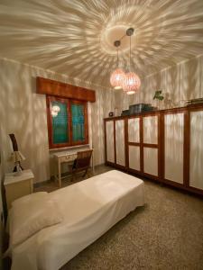Schlafzimmer mit einem großen weißen Bett und einer Decke in der Unterkunft Arcobalenotoscano Convivio in Pescia