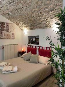 una camera con un grande letto con testiera rossa di 'Il Caratteristico' (centro storico) a Capistrello