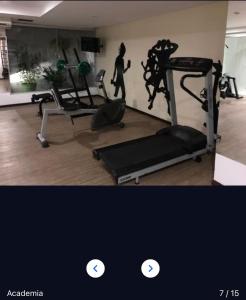 a gym with a treadmill and a woman walking in a room at Flat 427, Imperial Flat Tambau NOBILE in João Pessoa