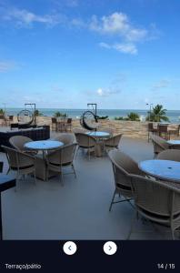 un patio con mesas y sillas y la playa en Flat 427, Imperial Flat Tambau NOBILE, en João Pessoa