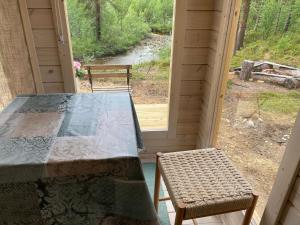 Lemmenjoen Lumo - Nature Experience & Accommodation في Lemmenjoki: طاولة وكرسيين في غرفة مع نافذة