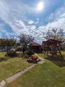 un jardín con una mesa de picnic y flores en la hierba en Casa Alex en Gălăuţaş