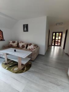 a living room with a couch and a table at Casa Alex in Gălăuţaş