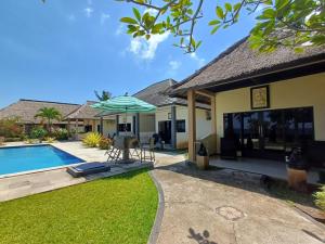 Casa con piscina y sombrilla en melaya beach resort 2, en Penginuman