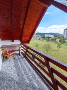 un balcón con un banco, una mesa y un campo en Casa Alex en Gălăuţaş