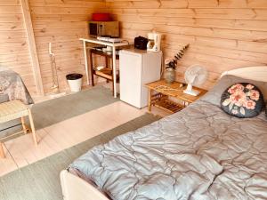 a room with a bed and a desk and a refrigerator at Lemmenjoen Lumo - Nature Experience & Accommodation in Lemmenjoki