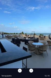 patio ze stołami i krzesłami oraz plażą w obiekcie Flat 406- Imperial Flat Tambaú NOBILE w mieście João Pessoa