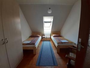 Zimmer im Dachgeschoss mit 2 Betten und einem Fenster in der Unterkunft Körtefa Vendégház Keszthely in Keszthely
