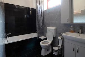 ein Badezimmer mit einer weißen Toilette und einem Waschbecken in der Unterkunft Körtefa Vendégház Keszthely in Keszthely + 7 Fotos