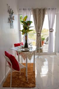 a dining room with a glass table with a plant on it at Royal Terrace III (Prince) in San Felipe de Puerto Plata