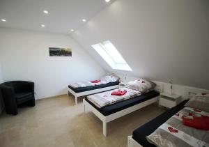 a attic room with two beds and a window at Apartment Hammersbach in Hammersbach