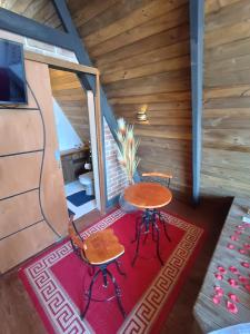 ein kleiner Tisch und Stühle auf einem Teppich in einer Hütte in der Unterkunft Chalés Capivari in Campos do Jordão