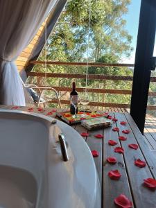 einen Tisch mit einer Badewanne und einer Flasche Wein in der Unterkunft Chalés Capivari in Campos do Jordão