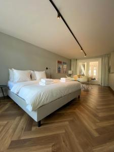 坎彭Studio 157, in de stad aan de gracht的卧室里有一张白色的大床和一张书桌