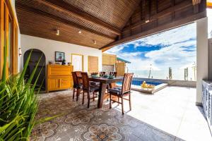 een eetkamer met een tafel en uitzicht op de oceaan bij Private Beach Front Villa, 3 Bedrooms! (CA3) in Ban Huai Sai Tai