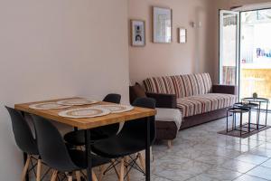 ein Wohnzimmer mit einem Tisch, Stühlen und einem Sofa in der Unterkunft Acropolis rooftop view, 200m from Neos kosmos metro station in Athen