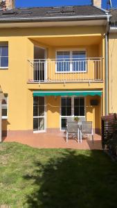 Casa amarilla con 2 sillas y balcón en Řadová Vila v Třebíči, en Třebíč