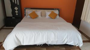 a bedroom with a white bed with orange walls at City and Palace view guest House in Udaipur