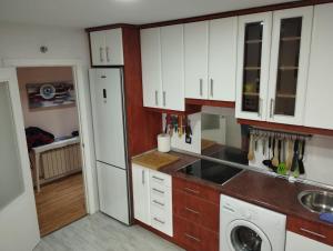 a kitchen with white cabinets and a washer at SORIA todas las comodidades y ÁTICO libre para eclipse y alguna fecha in Soria