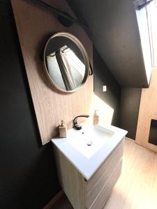 uma casa de banho com um lavatório branco e um espelho. em Ma Montagne Chic 2 em La Bresse