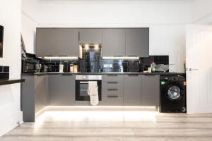 uma cozinha com electrodomésticos de aço inoxidável e uma máquina de lavar roupa em The Avenue Gem Stylish 2 Bed Stay in the Heart of Southampton em Southampton mais 20 fotografias