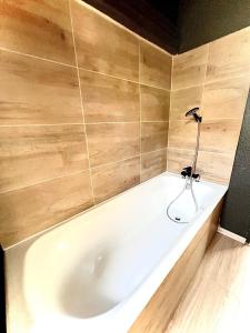 a white bath tub in a bathroom with wooden walls at Ma Montagne Chic 2 in La Bresse