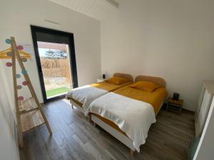 a bedroom with a bed and a large window at HOOliRé17 3étoiles in Ars-en-Ré