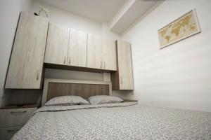 1 dormitorio con 1 cama y armarios de madera en AStar Apartments - SMALL, en Rădăuţi