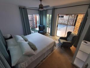 a bedroom with a bed and a sliding glass door at BellaBlues in Herolds Bay