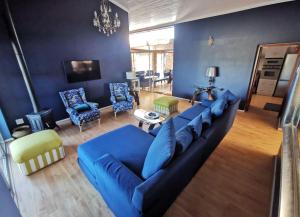 a living room with a blue couch and chairs at BellaBlues in Herolds Bay