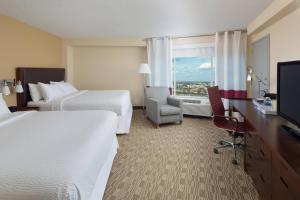 a hotel room with two beds and a television at Four Points by Sheraton Orlando International Drive in Orlando