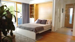 Un dormitorio con una cama y una planta en una habitación en Studio ELITE en Bled