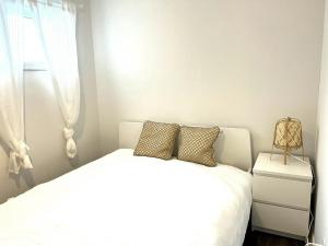 um quarto com uma cama branca e uma janela em Spacious one room in two floors apartment-102 em Montreal