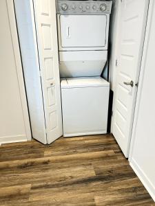 um pequeno frigorífico branco numa cozinha com piso em madeira em Spacious one room in two floors apartment-102 em Montreal