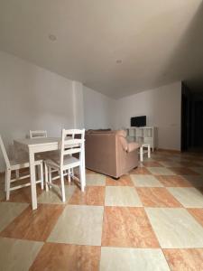 sala de estar con sofá, mesa y sillas en Asís 20.2 en Medina Sidonia