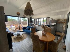 a living room with a table and a blue couch at HOOliRé17 3étoiles in Ars-en-Ré