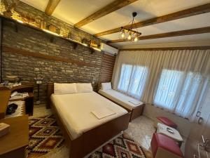 1 dormitorio con cama y pared de ladrillo en Ahmetaj Guest House en Gjirokastër