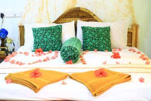 Una cama con dos toallas y flores. en Panoramic Royal Villa, en Sigiriya