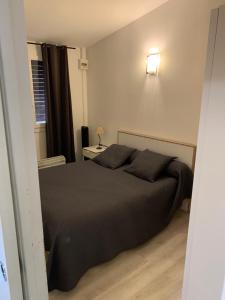 瓦爾拉普拉日的住宿－Les Trilles，卧室配有一张黑色的床,墙上有灯
